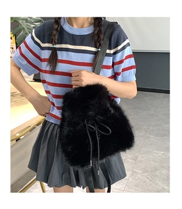 Detail of black faux fur drawstring bucket bag with adjustable nylon shoulder strap