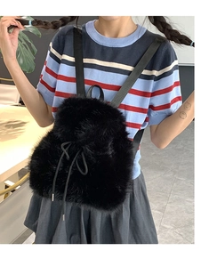 Close-up of black faux fur backpack featuring a secure drawstring closure and soft texture