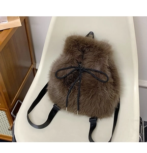 Detailed texture of brown faux fur backpack featuring a black drawstring bow closure