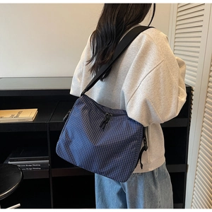 Detailed back view of a blue and white checkered canvas tote bag with adjustable strap