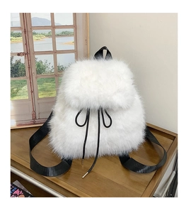 Detail of white faux fur backpack with drawstring closure and black nylon straps