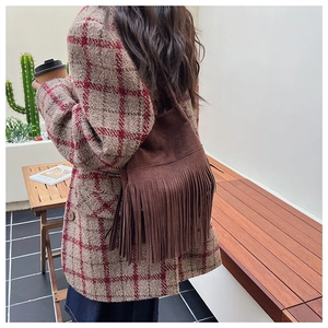 Detailed view of brown suede shoulder bag with bohemian long fringe details