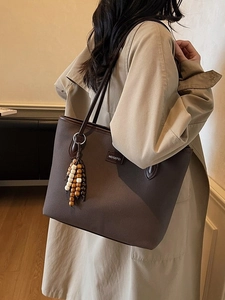 Minimalistische große braune Leder-Tragetasche mit Perlenanhänger am Model gezeigt