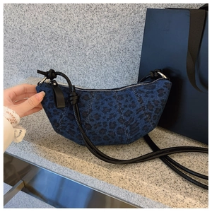 Dettaglio borsa a mezzaluna in denim leopardato con tracolla annodata e cerniera