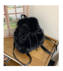 Close-up of black faux fur backpack texture with soft plush material and drawstring detail