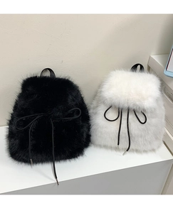 Detail shot of fluffy faux fur backpacks in black and white with cute bow decoration