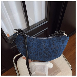 Dettaglio borsa a mezzaluna in denim leopardato con tracolla in pelle e cerniera