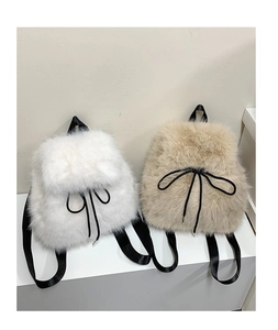Detail of plush faux fur backpacks in white and khaki with black contrast straps