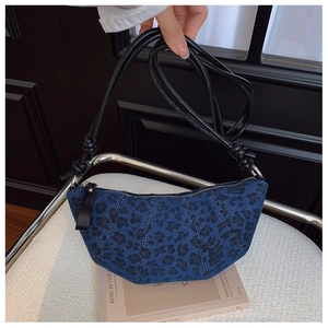 Dettaglio della borsa a mezzaluna in denim blu con stampa leopardata e tracolla a nodi