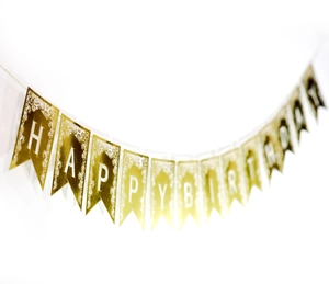 Gros plan de la bannière dorée Happy Birthday avec dentelle blanche et effet métal
