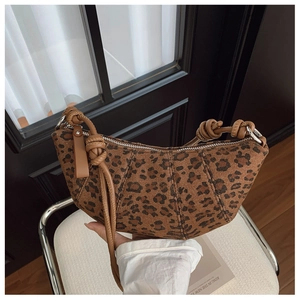 Dettaglio della borsa croissant leopardata con tessuto strutturato e tracolla in pelle