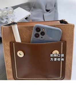 Detail view of the brown contrast backpack showing the large front pocket with dual magnetic snaps