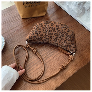Dettaglio della borsa a mezzaluna leopardata con tracolla in pelle e nodo decorativo