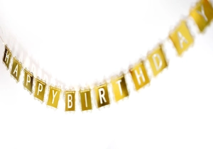 Détail de la bannière dorée Happy Birthday avec dentelle ajourée pour décoration de fête