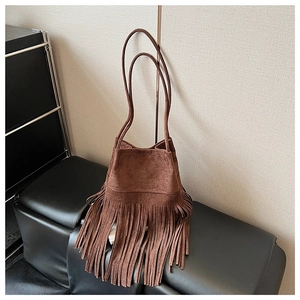 Detailed view of the dark brown suede bucket bag featuring long bohemian style tassels