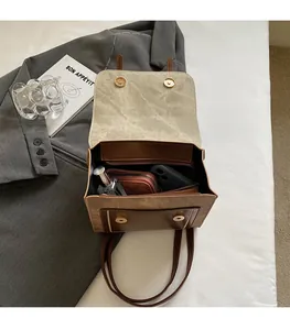 Macro view of the spacious internal compartments and gold magnetic buckle of the bag