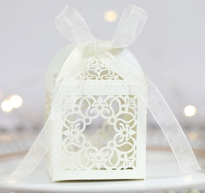 Détail de motifs floraux découpés au laser et nœud en organza sur boîte cadeau de mariage
