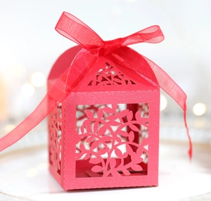 Gros plan d'une boîte à bonbons rouge découpée au laser avec ruban en organza chic