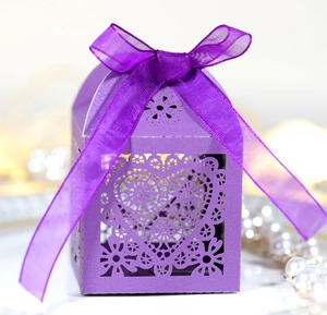 Detail der lila lasergeschnittenen Herz-Süßigkeitenbox mit eleganter Schleife für Hochzeiten