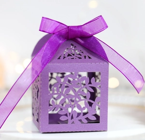Gros plan de la boîte à bonbons violette découpée au laser avec nœud en satin élégant