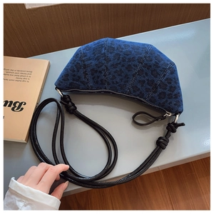 Dettaglio borsa a mezzaluna in denim leopardato blu scuro con tracolla annodata