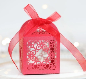 Motifs découpés au laser et ruban rouge sur la boîte à bonbons pour mariage chic