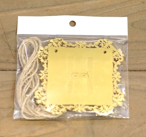 Détail de la lettre H dorée découpée au laser pour bannière Happy Birthday avec ficelle