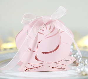 Detail of pink laser-cut rose candy box with shimmering pearl paper and white ribbon bow