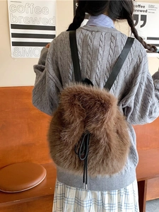 Chic brown faux fur backpack with drawstring closure shown on model in a cafe setting