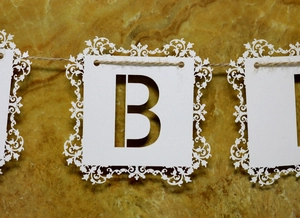 Détail de la bannière Happy Birthday en papier blanc découpé au laser avec motif dentelle