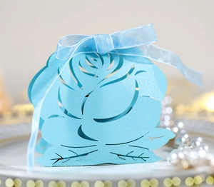 Detail of laser-cut rose hollow candy box in sky blue with elegant silk ribbon bow