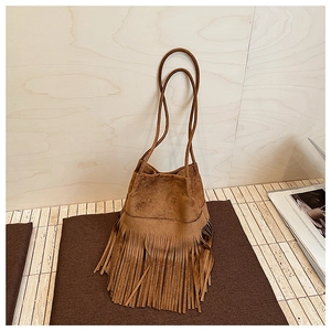 Close-up of the vintage brown suede texture and long fringe detail on the bucket bag