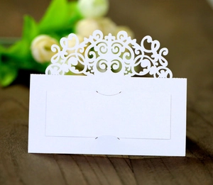 Marque-place blanc découpé au laser avec dentelle florale sur fond en bois brun