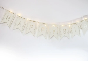 Détail de la banderole Happy Birthday ajourée au laser avec dentelle et guirlande LED