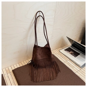 Close-up of brown suede bucket bag with long tassels and bohemian fringe details
