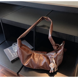 Detail of dark brown pleated Hobo bag in vintage PU leather with decorative knot strap