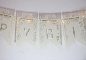 Détail de la guirlande Happy Birthday blanche découpée au laser avec dentelle