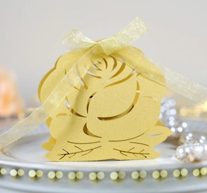 Detailed laser-cut yellow hollow paper gift box featuring exquisite rose patterns and silk ribbon