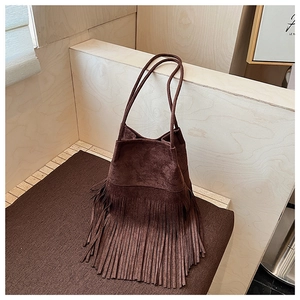 Close-up of dark brown suede bucket bag featuring long fringe details and dual straps