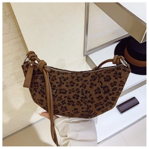 Dettaglio della borsa a mezzaluna leopardata con tracolla in pelle e nodi decorativi