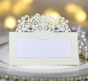 Gros plan d'un marque-place de mariage découpé au laser sur une assiette dorée chic