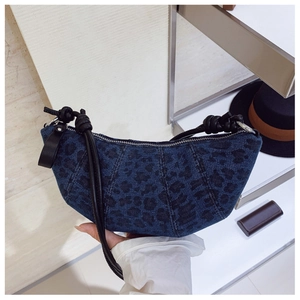 Dettaglio borsa a mezzaluna vintage in denim blu con stampa leopardata nera chic