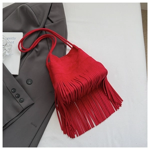 Detail of red suede bucket bag with long fringe tassels and woven shoulder strap