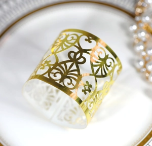 Macro shot of gold hollow-out lace candle wrap with heart patterns on a white plate