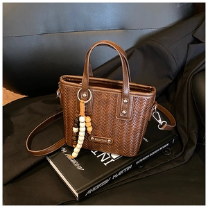 Détails du sac à main marron foncé tressé avec perles en bois et plaque logo argentée