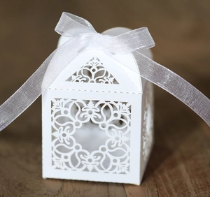 Détail de la boîte à bonbons de mariage découpée au laser avec ruban en soie blanc