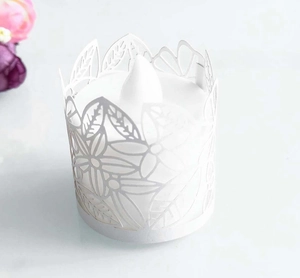 Detail view of white laser-cut paper tea light holder with floral patterns for LED candles