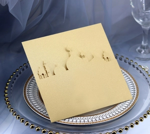 Detail of laser-cut gold glitter greeting card with mosque silhouette on a glass plate