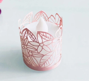 Detail of laser-cut floral pattern rose gold paper shade with LED electronic candle light