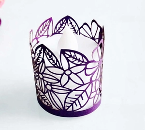 Macro detail of purple laser-cut floral paper shade with interior LED tea light candle